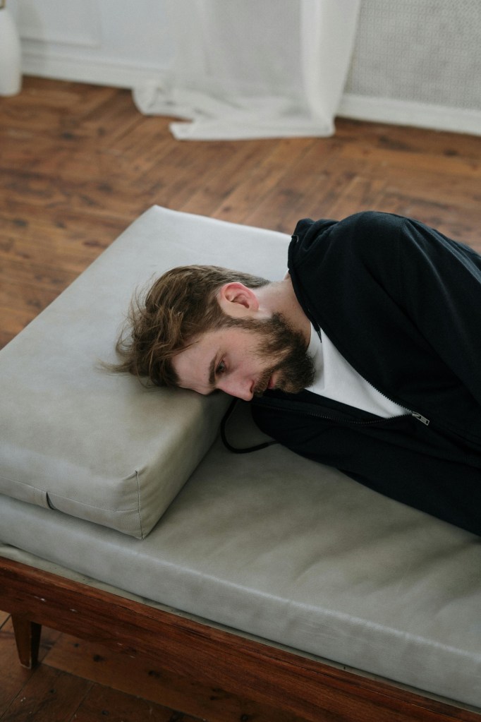 Man lying awake in bed at 3am, eyes open, unable to fall back asleep.