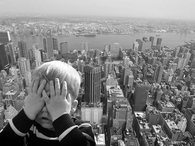 Young boy facing fear of heights in black and white lucid dream world.